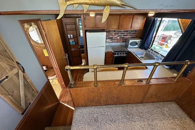 Slide: The Image of Interior of a 1987 Hilburn 14x45 houseboat kitchen with wood accents and nautical decor. - 7