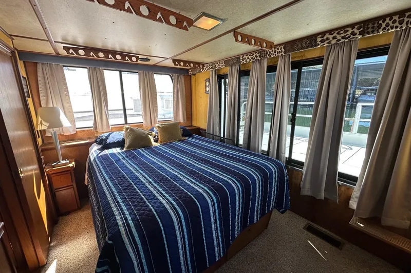 Slide: The Image of Cozy bedroom in 1987 Hilburn 14x45 houseboat with striped bedding and large windows. - 9