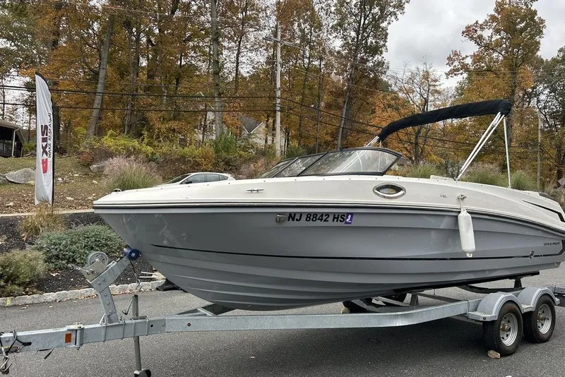 Slide: The Image of 2022 Bayliner VR6 Bowrider OB on trailer, parked roadside with autumn trees in background. - 4