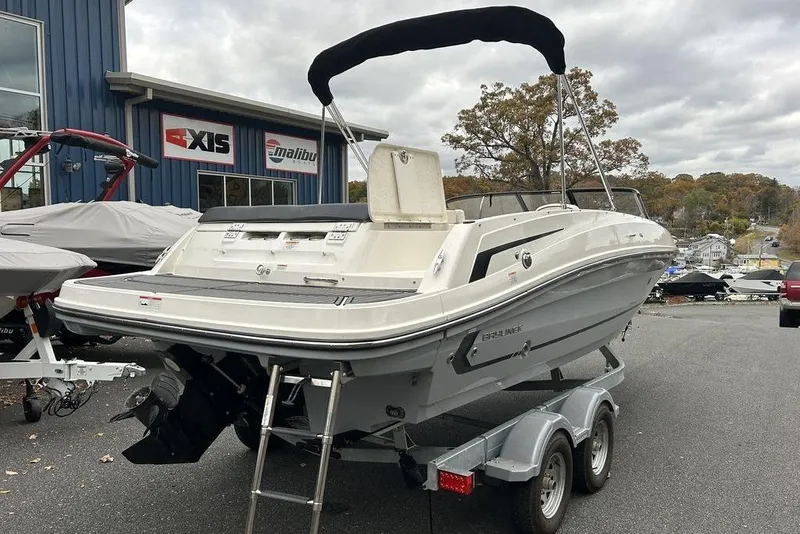 Slide: The Image of 2022 Bayliner VR6 Bowrider OB on trailer, parked outside dealership with overcast sky. - 8