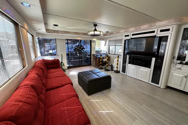 Slide: The Image of Luxurious 1998 Stardust Cruisers 16x86 interior with red sofa, modern decor, and entertainment center. - 3