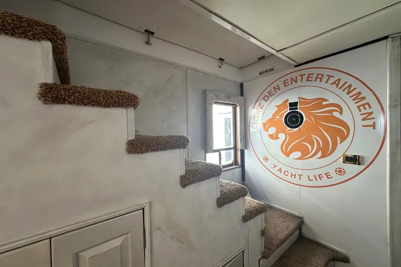 Slide: The Image of Carpeted stairs inside a 1998 Stardust Cruisers 16x86 yacht with "Lionz Den Entertainment" logo. - 6