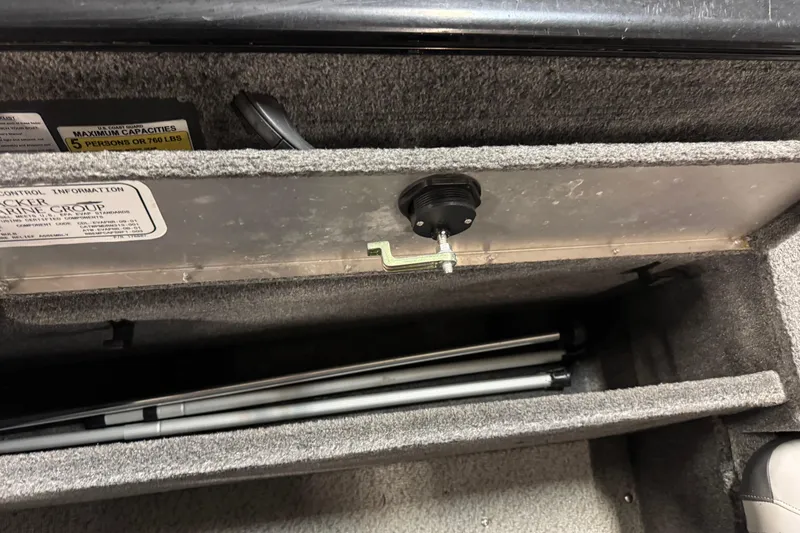 Slide: The Image of 2016 Tracker Pro Guide V-175 Combo storage compartment with capacity label and folded poles. - 17