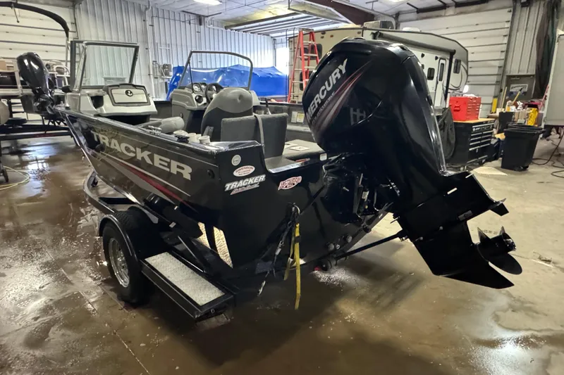Slide: The Image of 2016 Tracker Pro Guide V-175 Combo boat with Mercury engine in a garage setting. - 4