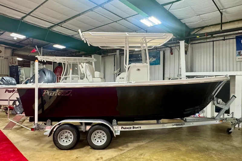 The Image of 2026 Parker 210 Coastal boat on trailer in indoor showroom setting. - 0