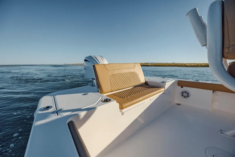 Slide: The Image of 2026 Caymas 24 HB boat interior with tan seating, cruising on open water. - 14