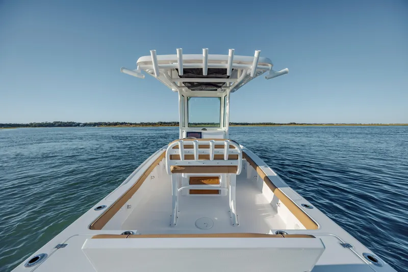 Slide: The Image of 2026 Caymas 24 HB boat on calm water, featuring sleek design and spacious deck. - 19