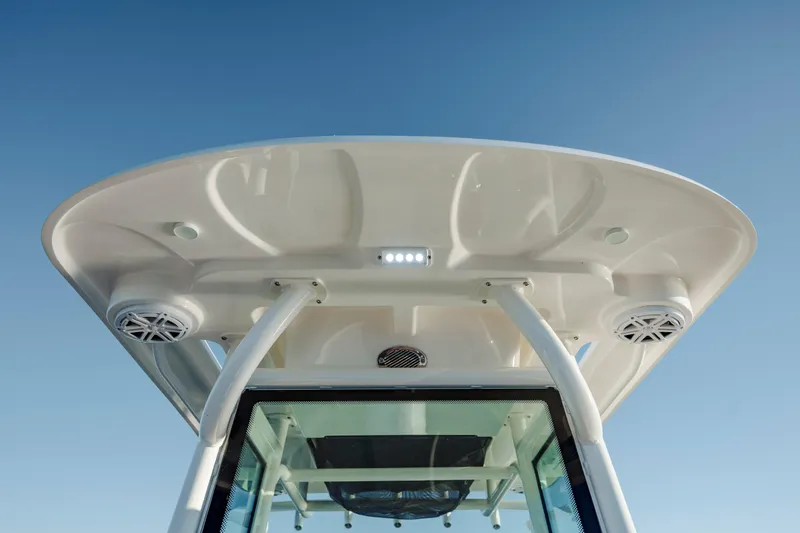 Slide: The Image of 2026 Caymas 24 HB boat roof with speakers and lights against clear sky. - 21