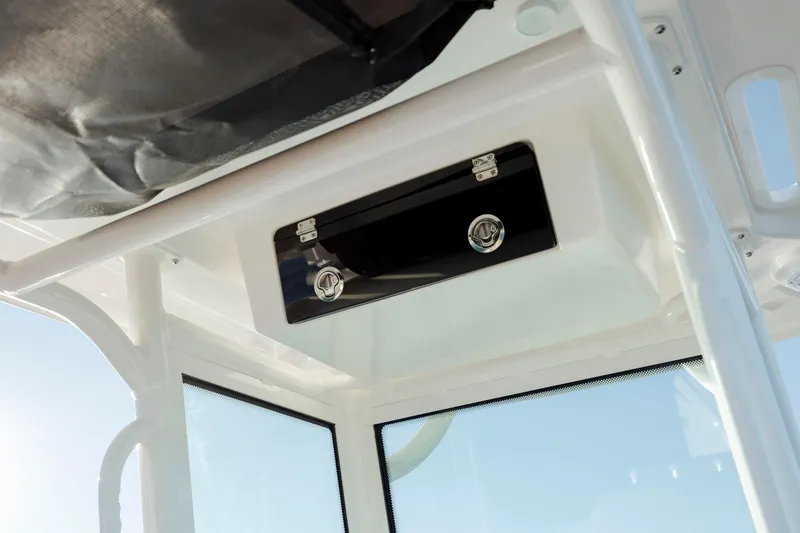 Slide: The Image of 2026 Caymas 24 HB boat interior with storage compartment and windows. - 22
