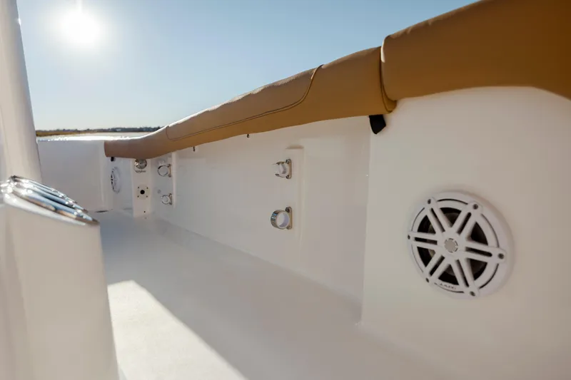 Slide: The Image of 2026 Caymas 24 HB boat interior with tan seating and built-in speakers. - 23
