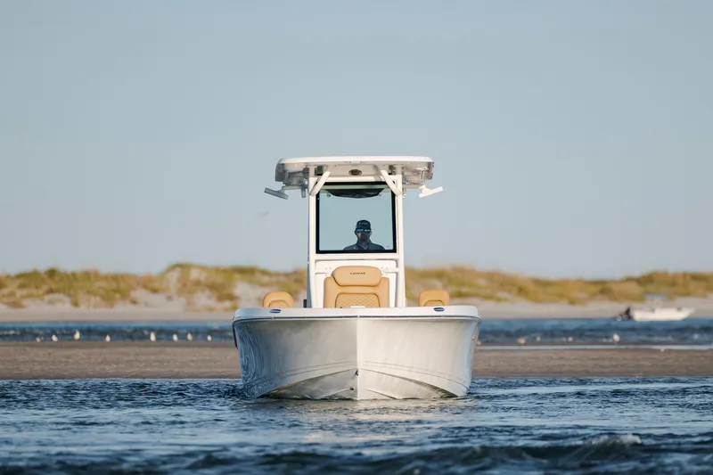 Slide: The Image of 2026 Caymas 24 HB boat navigating coastal waters with sandy shoreline in background. - 8