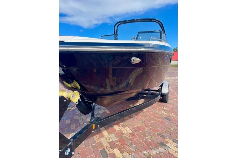 Slide: The Image of 2015 Yamaha Boats 242 Limited S on trailer, glossy black hull, clear blue sky. - 13