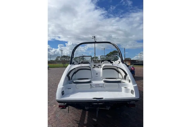 Slide: The Image of 2015 Yamaha Boats 242 Limited S, rear view, parked on brick pavement under a cloudy sky. - 3