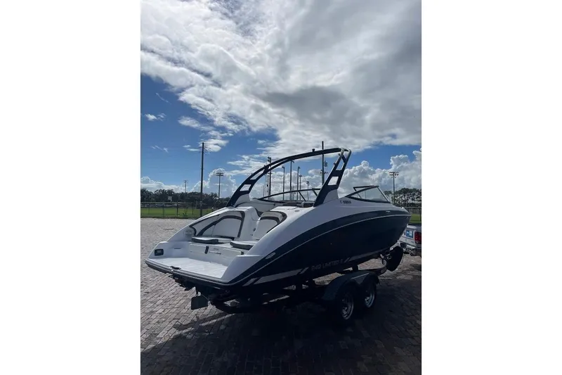 Slide: The Image of 2015 Yamaha Boats 242 Limited S on trailer under cloudy sky. - 4