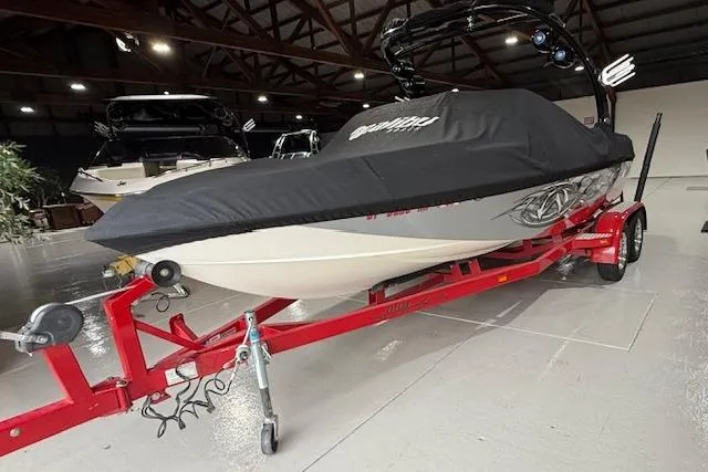 Slide: The Image of 2007 Malibu Wakesetter 20 VTX boat on red trailer, covered, in indoor storage. - 21