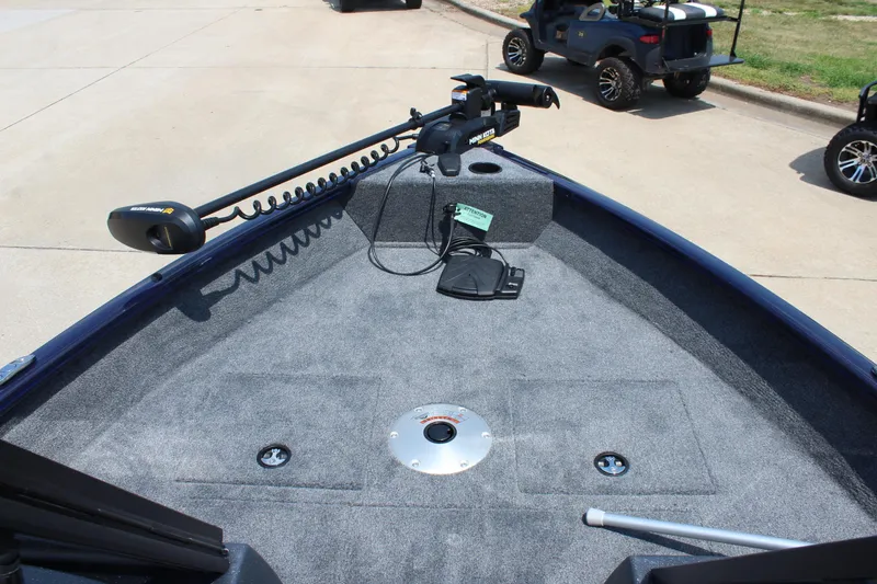 Slide: The Image of 2026 Tracker Pro Guide V-16 WT boat deck with trolling motor and carpeted surface. - 13