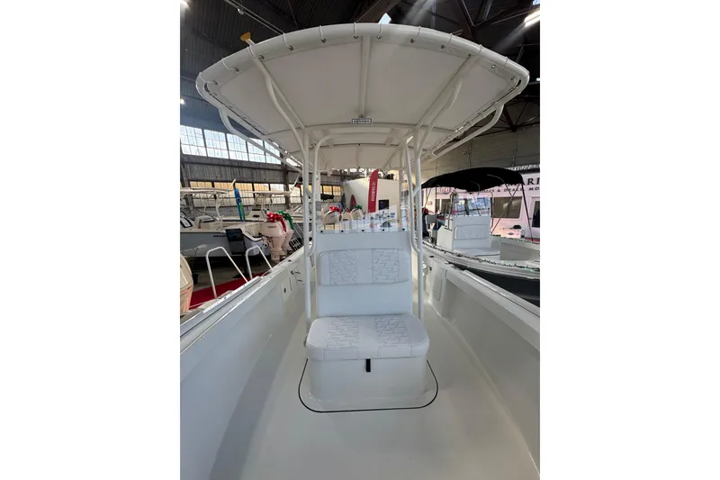 Slide: The Image of 2026 Parker 210 Coastal boat interior with seating and canopy in a showroom. - 11