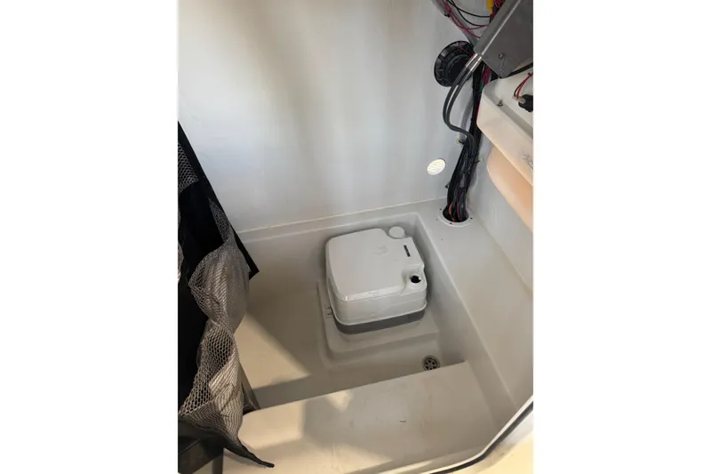 Slide: The Image of Interior of 2026 Parker 210 Coastal boat featuring compact marine toilet setup. - 12
