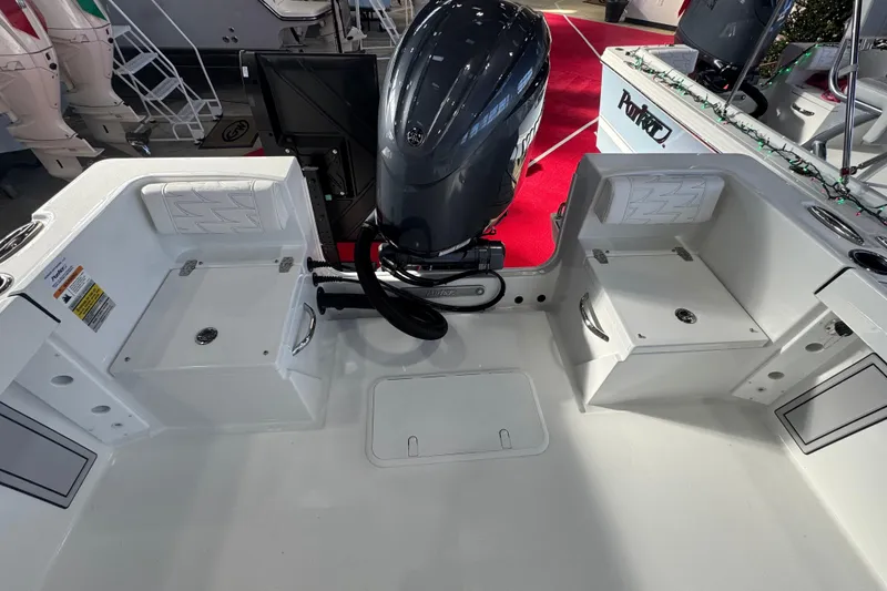 Slide: The Image of 2026 Parker 210 Coastal boat interior with motor, white seating, and storage compartments. - 6