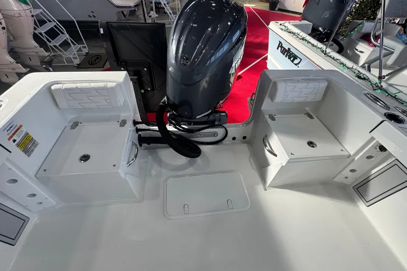 Slide: The Image of 2026 Parker 210 Coastal boat interior with motor, storage compartments, and seating. - 7
