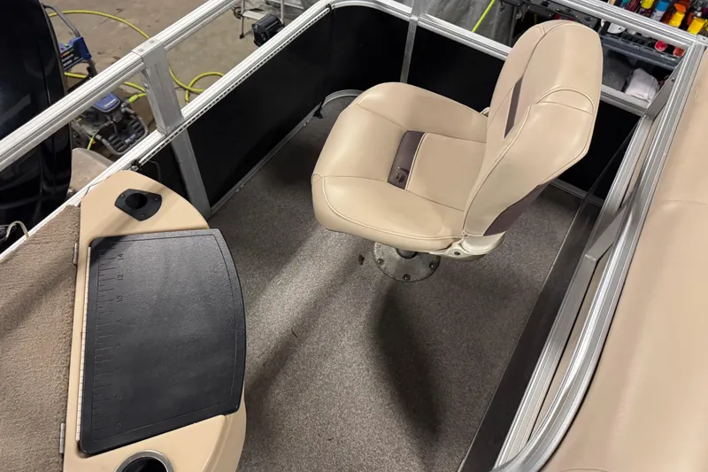 Slide: The Image of 2018 Sun Tracker Bass Buggy 18 DLX interior with beige captain's chair and control panel. - 16