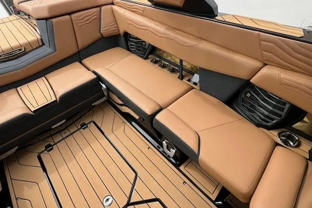 Slide: The Image of 2025 Nautique Super Air Nautique G23 interior with luxurious tan seating and sleek design. - 11