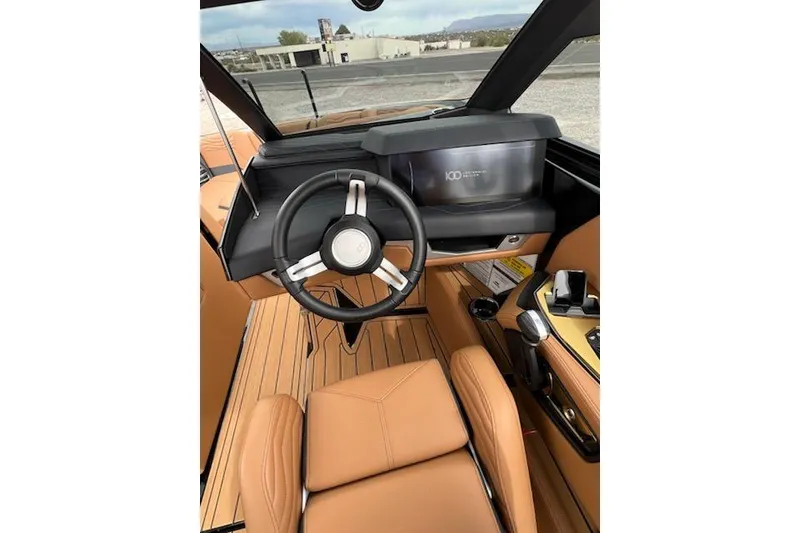 Slide: The Image of 2025 Nautique Super Air Nautique G23 interior with tan leather seats and modern steering wheel. - 15