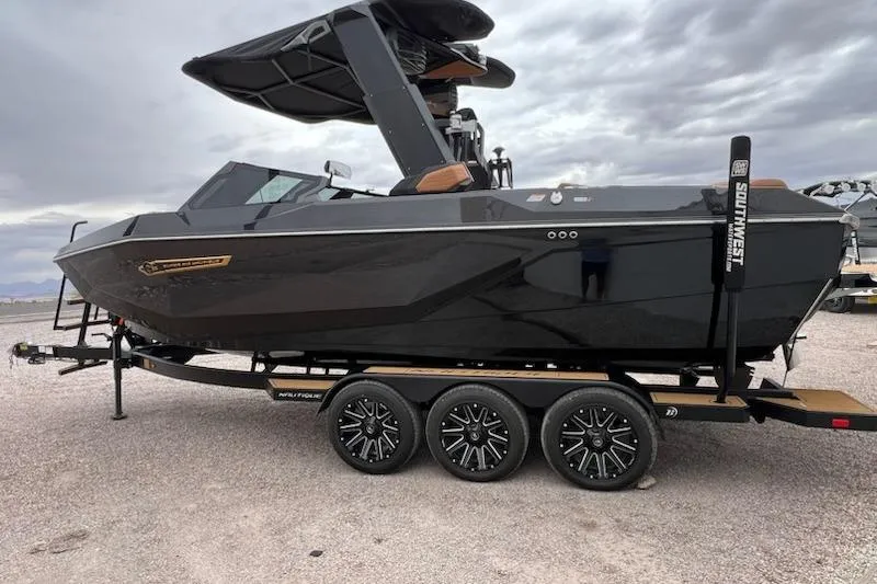 Slide: The Image of 2025 Nautique Super Air Nautique G23 boat on trailer, sleek black design, overcast sky. - 4