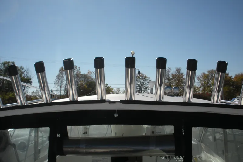 Slide: The Image of 2006 Baha Cruisers 277 GLE boat with multiple rod holders under clear blue sky. - 21