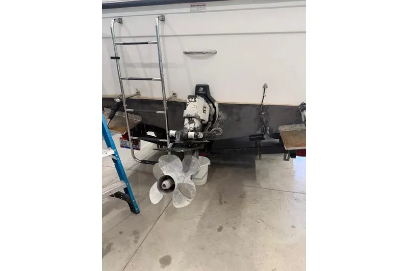 Slide: The Image of 2006 Baha Cruisers 277 GLE boat stern with propeller and ladder in a garage. - 27