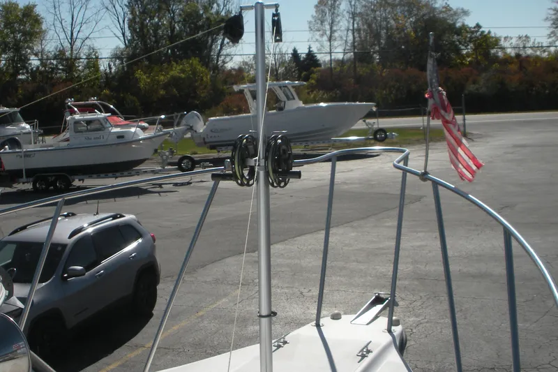 Slide: The Image of 2006 Baha Cruisers 277 GLE boat with American flag, parked near other boats and a vehicle. - 4