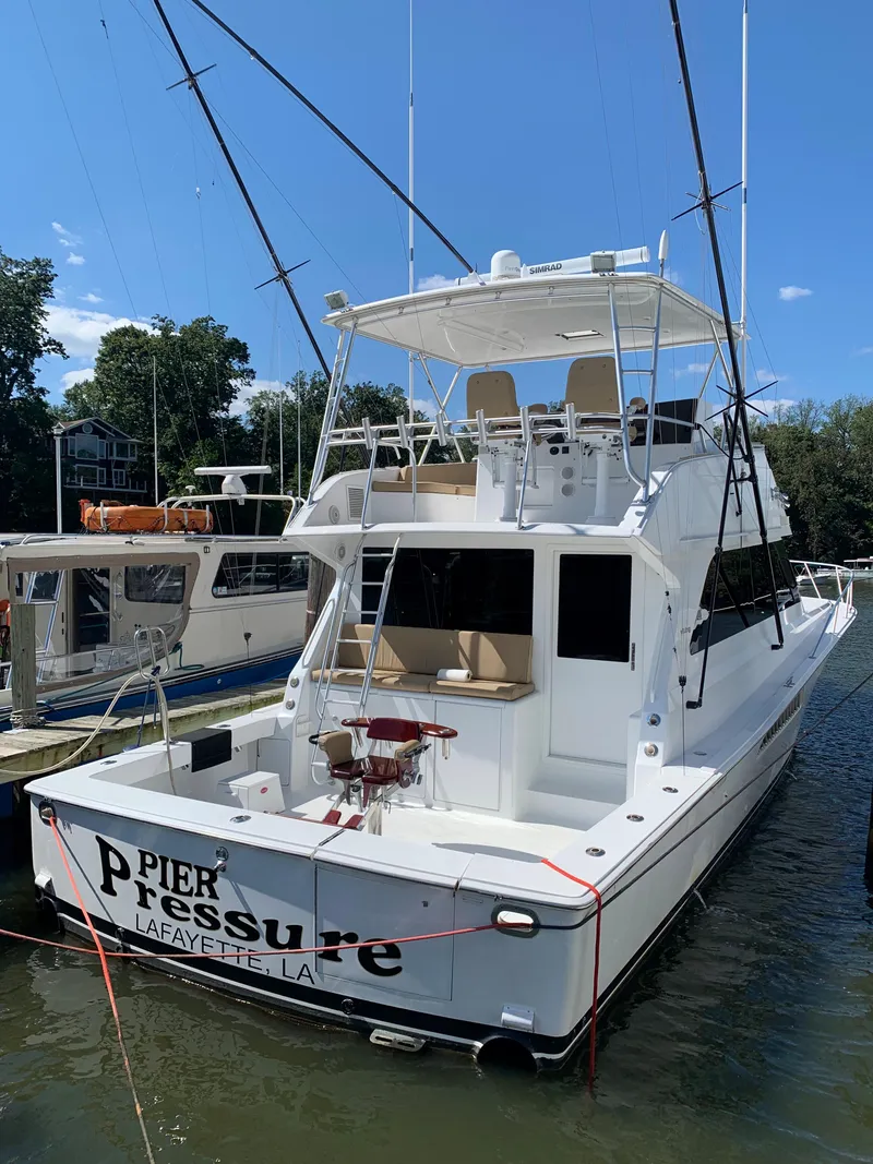 The Image of Viking 50 Convertible 2000 yacht docked, featuring spacious deck and fishing equipment. - 0