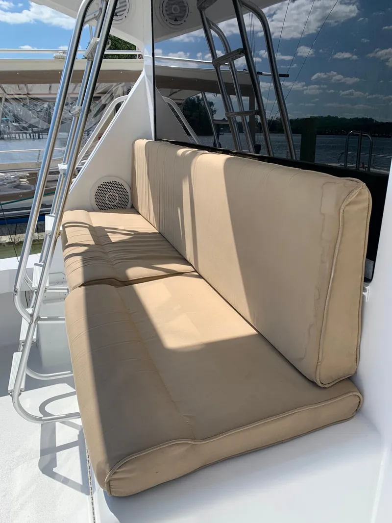 Slide: The Image of Beige cushioned seating on 2000 Viking 50 Convertible yacht, with metal frame and outdoor view. - 12