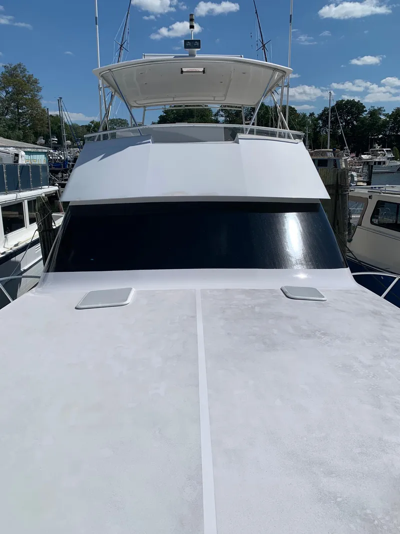 Slide: The Image of 2000 Viking 50 Convertible yacht docked under a clear blue sky. - 17