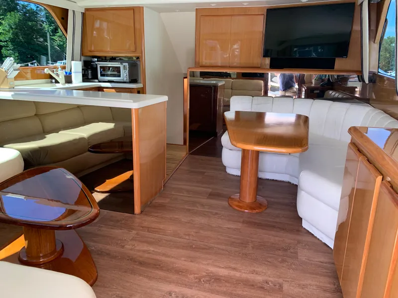 Slide: The Image of Interior of a 2000 Viking 50 Convertible yacht with modern furnishings and wood accents. - 20