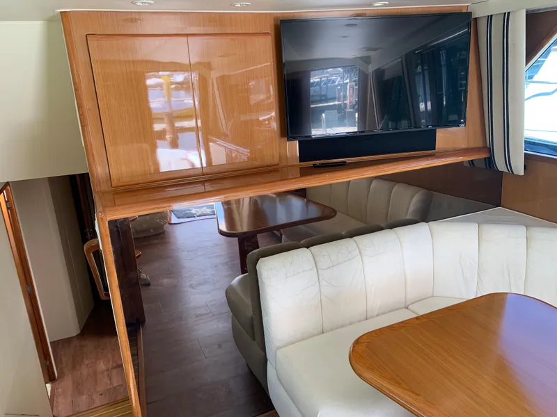 Slide: The Image of Interior of 2000 Viking 50 Convertible yacht with white seating and wooden table. - 25
