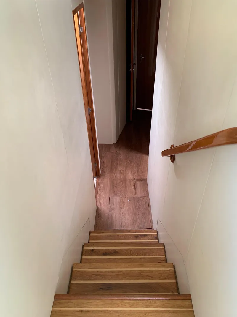 Slide: The Image of Staircase inside 2000 Viking 50 Convertible yacht with wooden steps and handrail. - 26