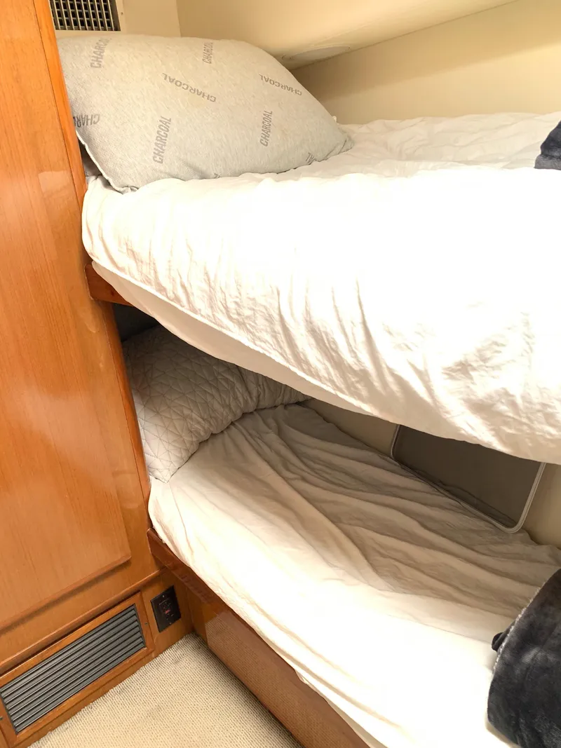 Slide: The Image of Bunk beds in a 2000 Viking 50 Convertible yacht cabin with wooden paneling. - 27