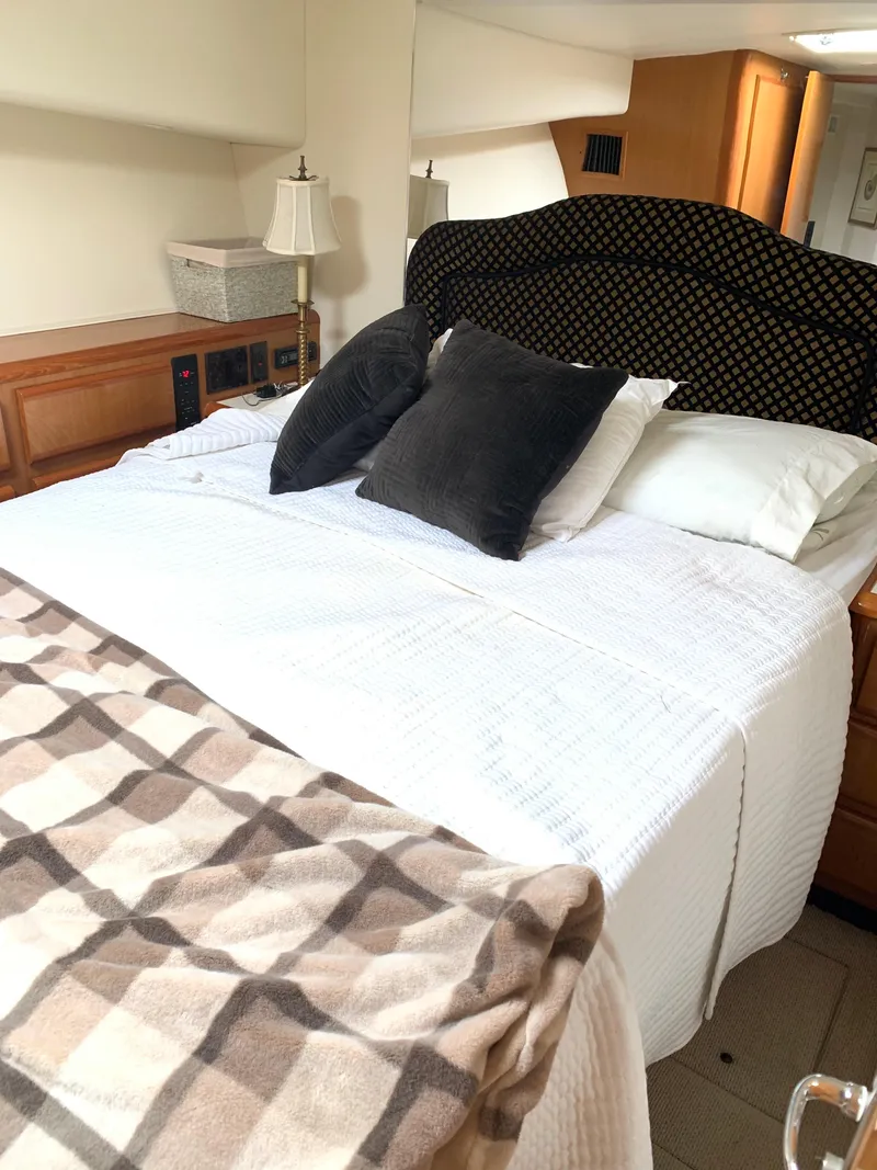 Slide: The Image of Cozy bedroom in 2000 Viking 50 Convertible yacht with plush bedding and elegant decor. - 29