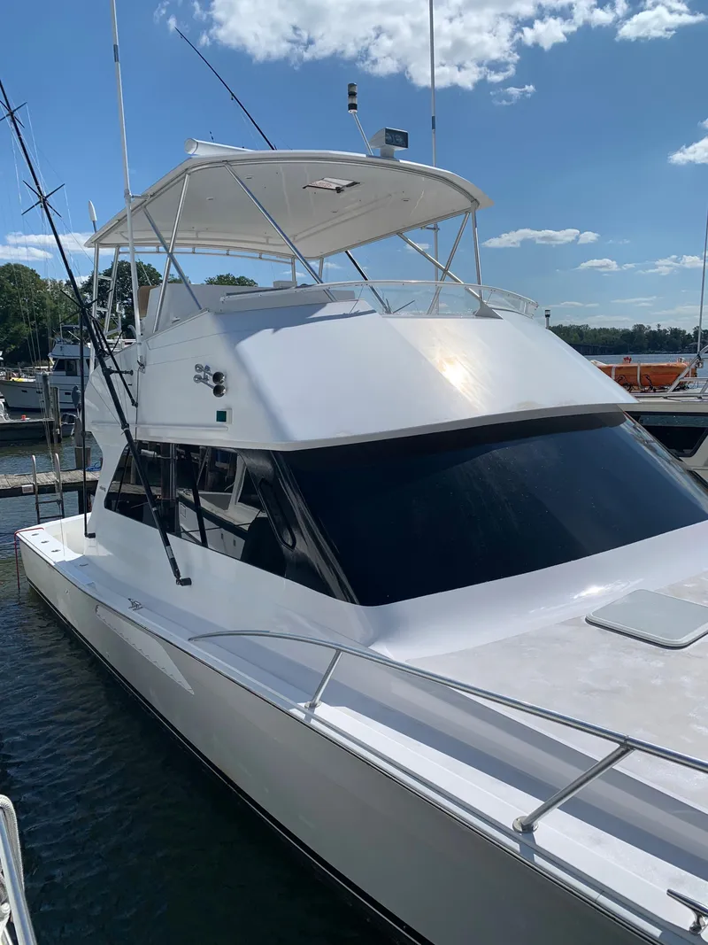 Slide: The Image of 2000 Viking 50 Convertible yacht docked under a clear blue sky. - 3
