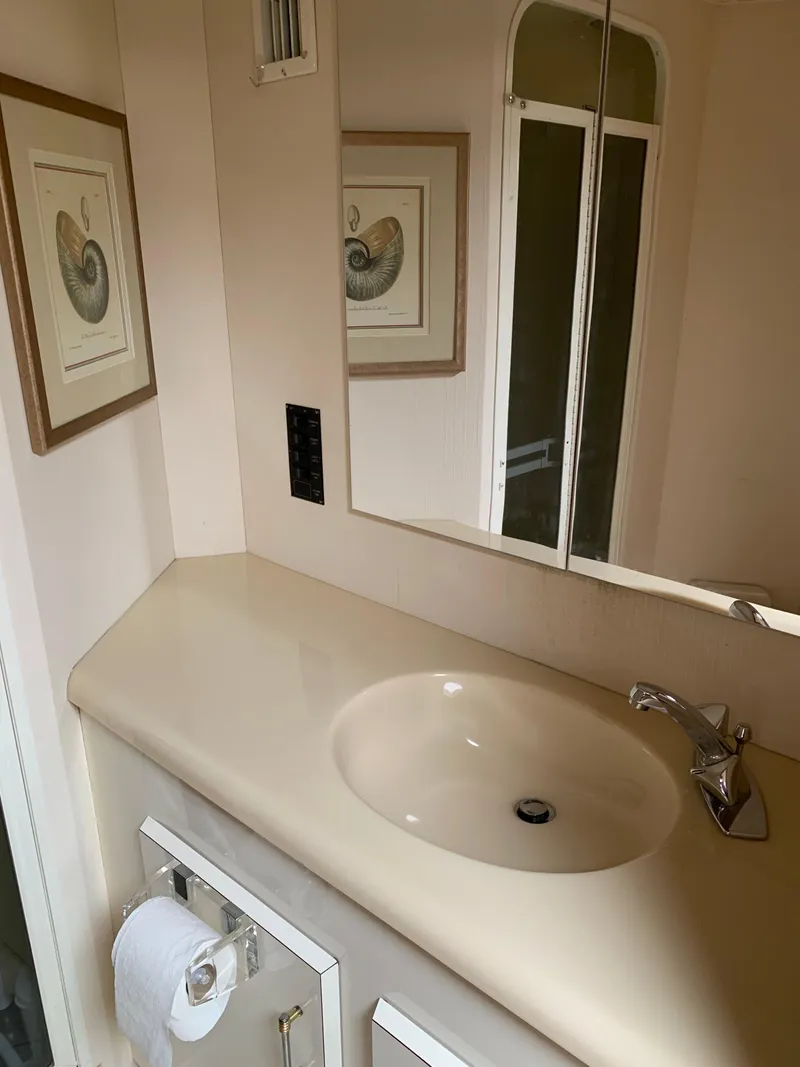 Slide: The Image of Bathroom vanity in 2000 Viking 50 Convertible yacht with mirror and artwork. - 31
