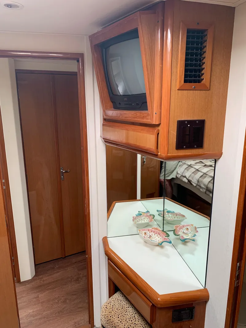 Slide: The Image of Interior of a 2000 Viking 50 Convertible yacht with TV and decorative items. - 33