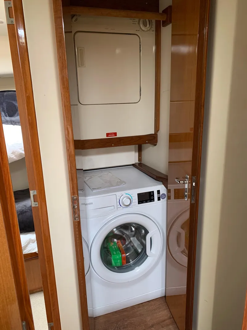 Slide: The Image of Laundry area inside a 2000 Viking 50 Convertible yacht with washer and dryer. - 34