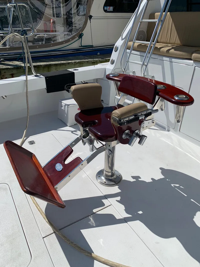 Slide: The Image of Fishing chair on 2000 Viking 50 Convertible yacht deck, featuring polished wood and metal design. - 6