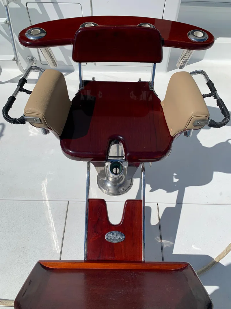 Slide: The Image of Luxury fishing chair on 2000 Viking 50 Convertible yacht, featuring polished wood and cushioned armrests. - 7