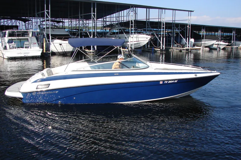 Slide: The Image of 2008 Crownline 270 BR boat docked in marina, featuring blue and white design. - 1