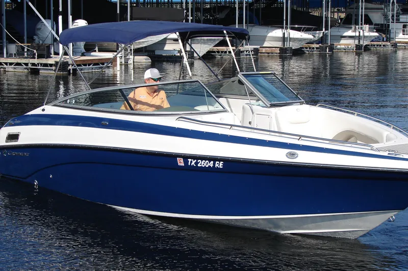 Slide: The Image of 2008 Crownline 270 BR boat with blue hull, docked on calm water. - 11