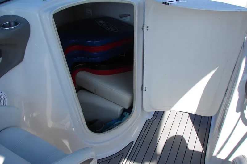 Slide: The Image of Open storage compartment on 2008 Crownline 270 BR boat, showing interior seating and equipment. - 14