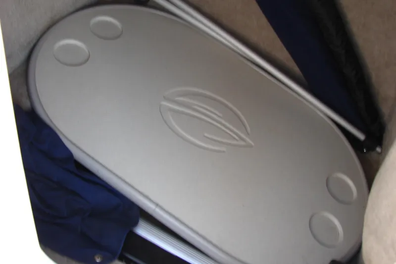 Slide: The Image of Storage compartment in a 2008 Crownline 270 BR boat, featuring a fitted table. - 26