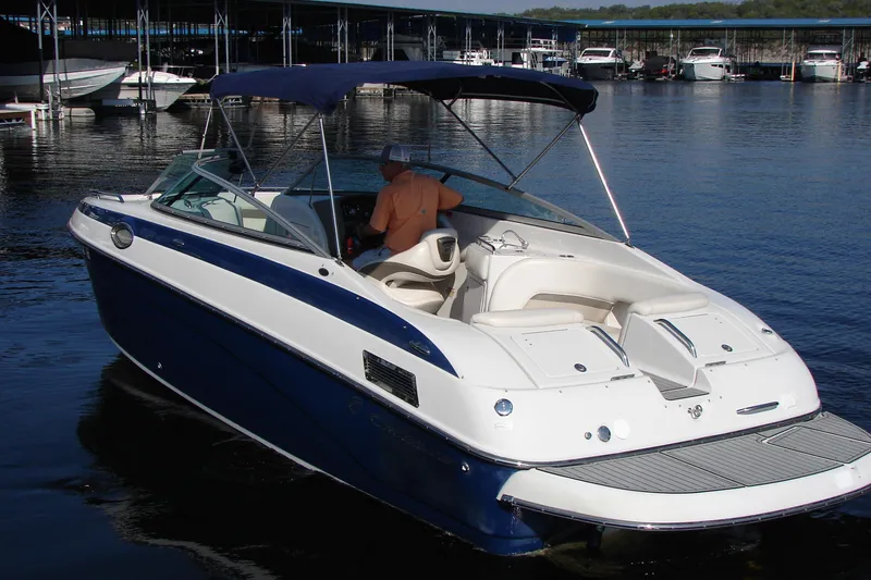 Slide: The Image of 2008 Crownline 270 BR boat with blue and white exterior, docked at marina. - 4